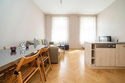 a kitchen and living room with a counter and a table at Cozy and sunny apartment in uptown in Prague