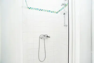 a shower with a shower head in a bathroom at Cozy and sunny apartment in uptown in Prague