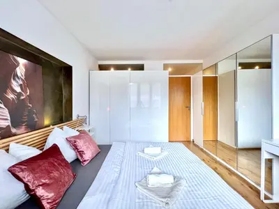a bedroom with a large bed with red pillows at Jana's apartment, free parking in Prague