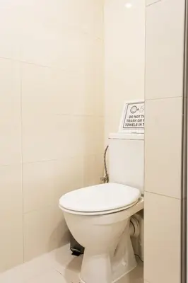a white toilet in a white tiled bathroom at Cozy modern studio in Prague's absolute center in Prague