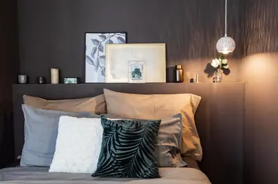a bedroom with a bed with a headboard and pillows at Cozy modern studio in Prague's absolute center in Prague