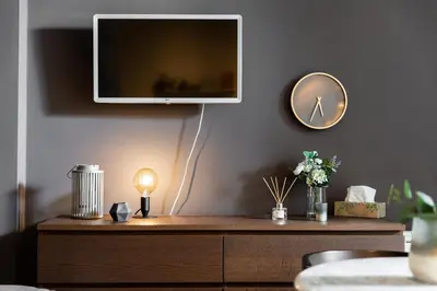 a tv on a wall above a wooden dresser at Cozy modern studio in Prague's absolute center in Prague