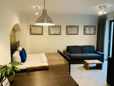 a living room with a bed and a couch at Cozy friendly place with free parking in Prague