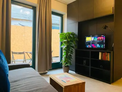 a living room with a bed and a tv at Cozy friendly place with free parking in Prague
