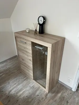 a wooden cabinet with a clock on top of it at Apartmán Jenčice v Českém středohoří in Jenčice