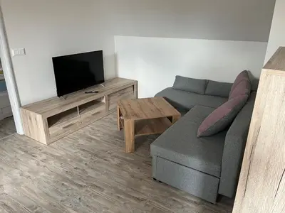 a living room with a couch and a flat screen tv at Apartmán Jenčice v Českém středohoří in Jenčice