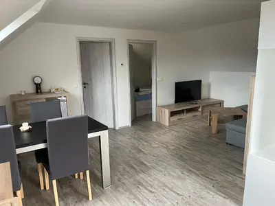 a living room with a table and a television at Apartmán Jenčice v Českém středohoří in Jenčice