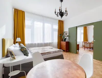 a room with a bed and a table and chairs at TurnKey I Vintage Terrace Apartment in Prague