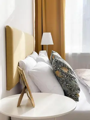 a bed with white pillows and a table next to a window at TurnKey I Vintage Terrace Apartment in Prague