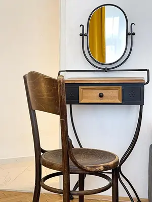 a chair in front of a desk with a mirror at TurnKey I Vintage Terrace Apartment in Prague