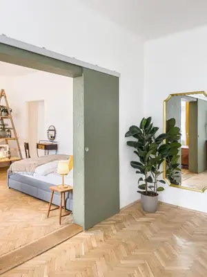 a bedroom with a bed and a mirror and a potted plant at TurnKey I Vintage Terrace Apartment in Prague