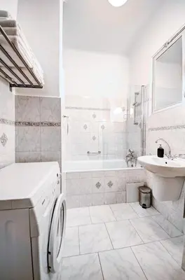 a white bathroom with a sink and a washing machine at TurnKey I Vintage Terrace Apartment in Prague