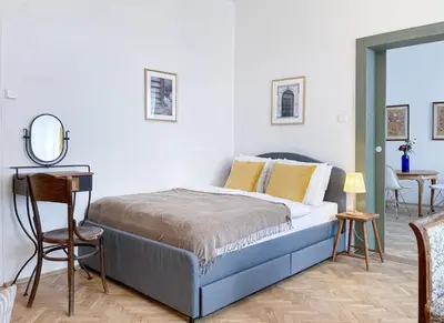 a bedroom with a bed with a mirror and a table at TurnKey I Vintage Terrace Apartment in Prague