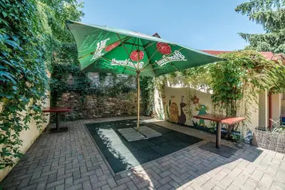 a patio with a table and a green umbrella at Antonio Residence in Škvorec