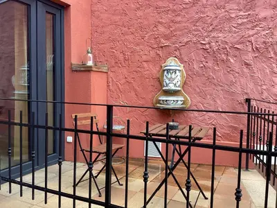 a clock on the side of a pink wall with chairs at Antonio Residence in Škvorec
