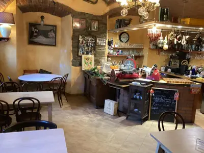 a restaurant with a counter and tables and chairs at Antonio Residence in Škvorec