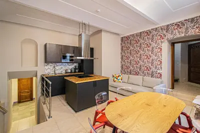a kitchen and living room with a wooden table and a dining room at Modern and Spacious Apartments in City Center in Prague