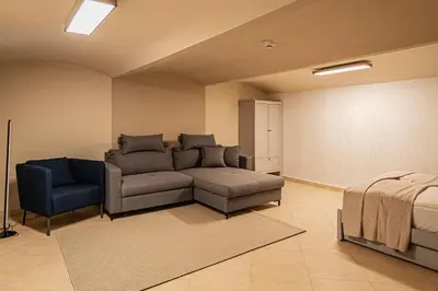 a living room with a couch and a chair at Modern and Spacious Apartments in City Center in Prague