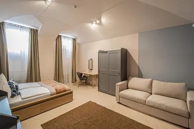 a bedroom with a bed and a couch and a desk at Modern and Spacious Apartments in City Center in Prague
