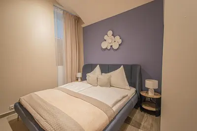 a bedroom with a bed with a purple wall at Modern and Spacious Apartments in City Center in Prague