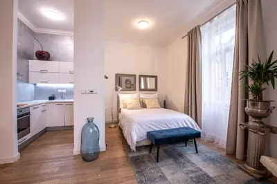 a white bedroom with a bed and a kitchen at Modern Downtown APT - renovated, on ideal location in Prague