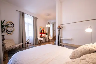 a bedroom with a white bed and a table at Modern Downtown APT - renovated, on ideal location in Prague