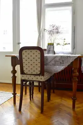 a table with a chair in a room with a window at Old Town Konviktská - Bohemian Residence in Prague