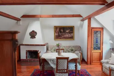a living room with a table and a fireplace at Old Town Konviktská - Bohemian Residence in Prague