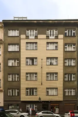 an apartment building with windows and cars parked in a parking lot at Old Town Konviktská - Bohemian Residence in Prague