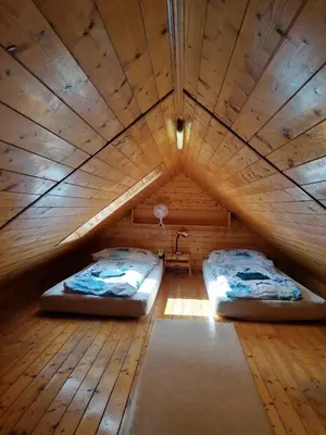 two beds in a room with a wooden ceiling at Chata Slapy - Ždáň in Slapy