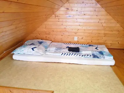 a bed in the corner of a wooden room at Chata Slapy - Ždáň in Slapy