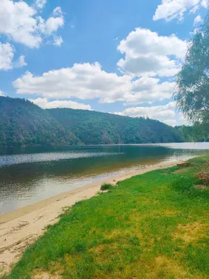 a beach next to a body of water at Chata Slapy - Ždáň in Slapy