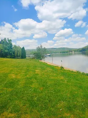 a grassy field next to a body of water at Chata Slapy - Ždáň in Slapy