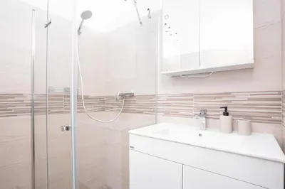 a white bathroom with a shower and a sink at Prague Days - Two-bedroom Apartment with Workspace right next to Old Town Square in Prague