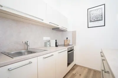 a kitchen with white cabinets and a sink at Prague Days - Two-bedroom Apartment with Workspace right next to Old Town Square in Prague
