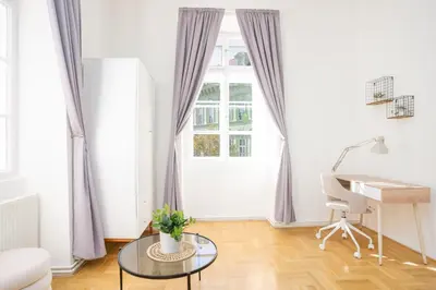 a white living room with a desk and a window at Prague Days - Two-bedroom Apartment with Workspace right next to Old Town Square in Prague