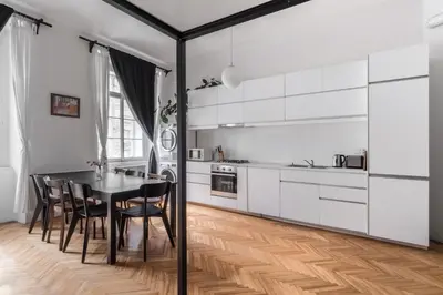 a kitchen with white cabinets and a table and chairs at Prague Days - Apartment with Chill Zone right next to Wenceslas Square in Prague