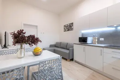 a kitchen and living room with a table and a couch at Kinsky Garden Apartments and Suites by Dwellfort in Prague