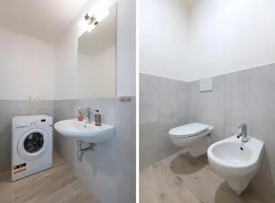 a bathroom with a toilet sink and a washing machine at Kinsky Garden Apartments and Suites by Dwellfort in Prague