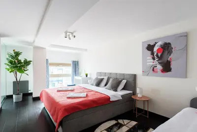 a bedroom with a bed with a red blanket at 2-level apartments on Krizikova near the metro in Prague
