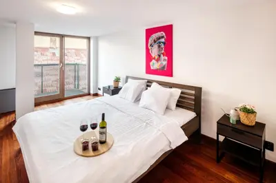 a bedroom with a bed with a tray of wine bottles at 2-level apartments on Krizikova near the metro in Prague