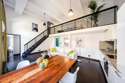 a kitchen and living room with a wooden table in a house at 2-level apartments on Krizikova near the metro in Prague
