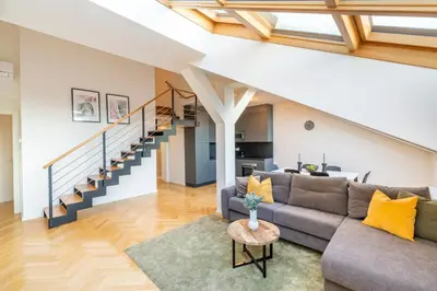 a living room with a couch and a staircase at Petrin Tower Residence in Prague