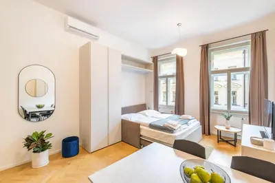 a bedroom with a bed and a table with a bowl of fruit at Petrin Tower Residence in Prague