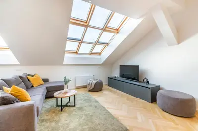 a living room with a couch and a tv at Petrin Tower Residence in Prague