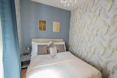 a bedroom with a white bed with a floral wallpaper at National Museum 3BDR Golden Stork Spot in Prague