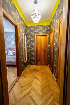 a hallway with blue and yellow walls and a chandelier at National Museum 3BDR Golden Stork Spot in Prague