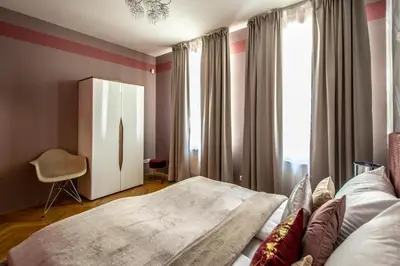 a bedroom with a bed and a chair and a window at National Museum 3BDR Golden Stork Spot in Prague