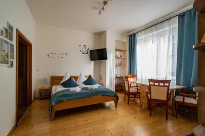 a bedroom with a bed and a dining room with a table at Bright Ruterra Apartment in the Heart of Prague in Prague