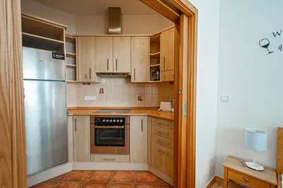 a kitchen with wooden cabinets and a stainless steel refrigerator at Bright Ruterra Apartment in the Heart of Prague in Prague